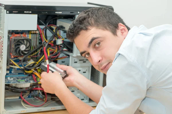 Young technician working on broken computer in office — Stock Photo, Image