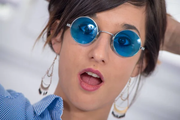 Schöne junge brünette Frau mit blauer Brille — Stockfoto