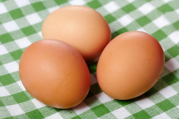 Tre färska ägg på grön handduk — Stockfoto