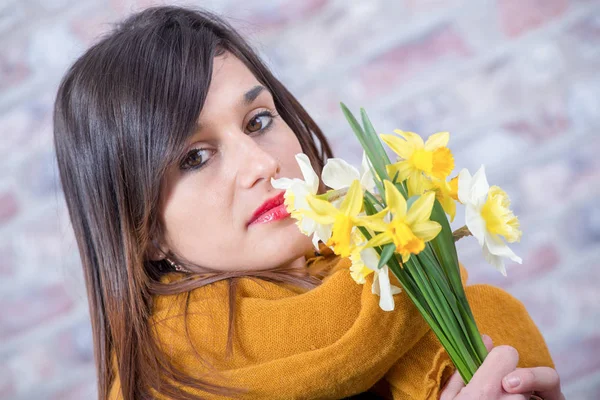 Joven morena con ramo de narcisos —  Fotos de Stock