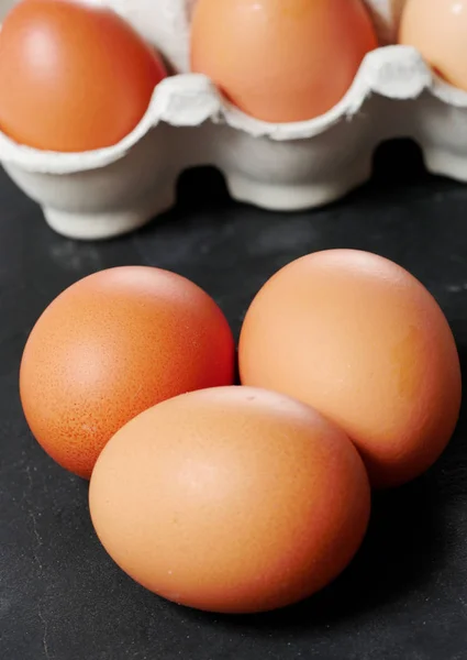 Tre färska ägg på svart skiffer — Stockfoto