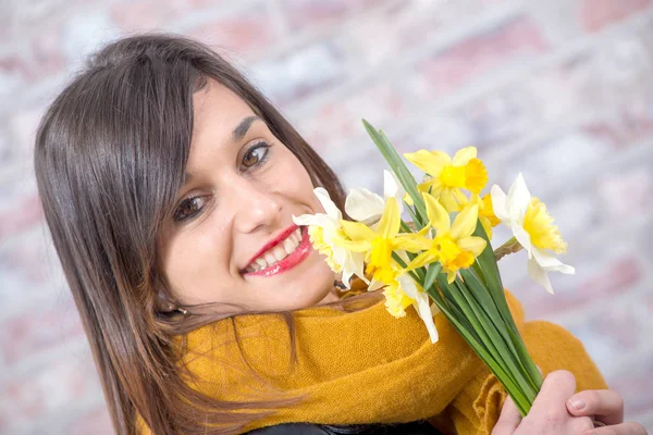 Giovane donna bruna con bouquet di narcisi — Foto Stock