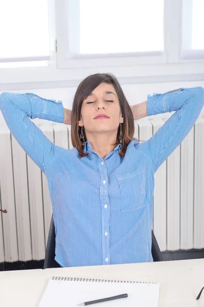 Young brunette woman in blue shirt relaxes — Stock Photo, Image