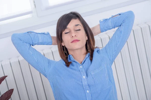 Giovane donna bruna in camicia blu si rilassa — Foto Stock