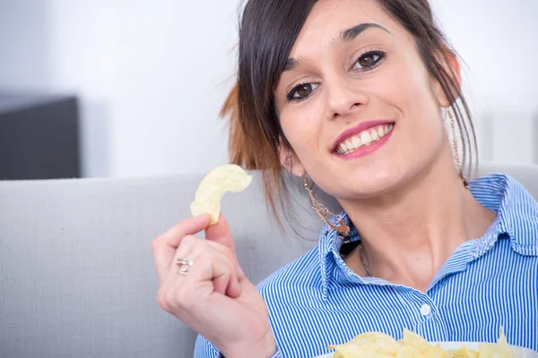 young brunette woman eating chips