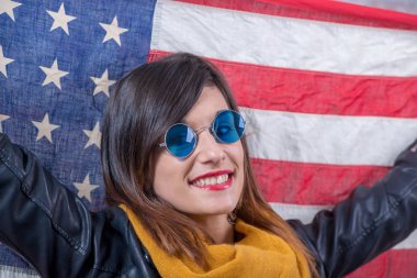 Amerikan bayrağı önünde mavi gözlüklü genç esmer