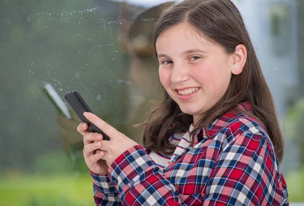 Tiener met behulp van de telefoon in de buurt van het venster — Stockfoto