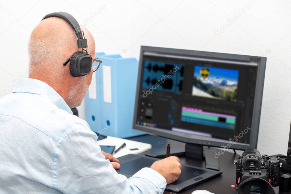 mature man designer using graphics tablet for video editing