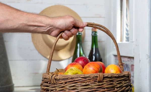 Hombre sosteniendo una cesta llena de manzanas — Foto de Stock