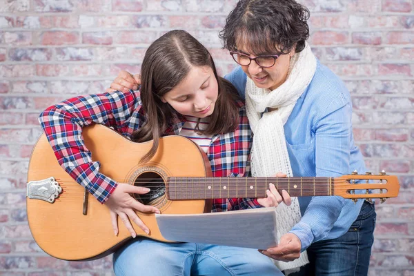 Joven adolescente aprendiendo a tocar la guitarra con su profesor —  Fotos de Stock