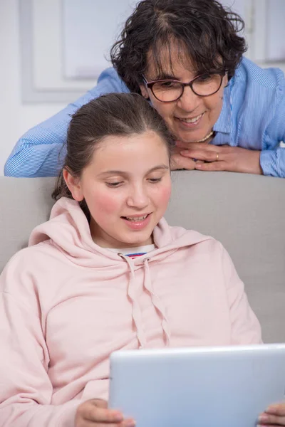 Usměvavá máma a dcera doma pomocí tabletového počítače — Stock fotografie