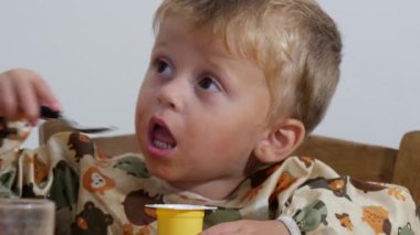 İki yaşında bir çocuk yoğurt yiyor.