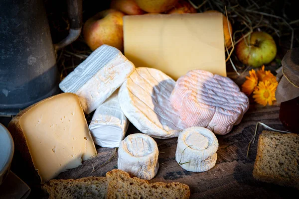 Verschiedene köstliche französische Käsesorten auf rustikalem Tisch — Stockfoto