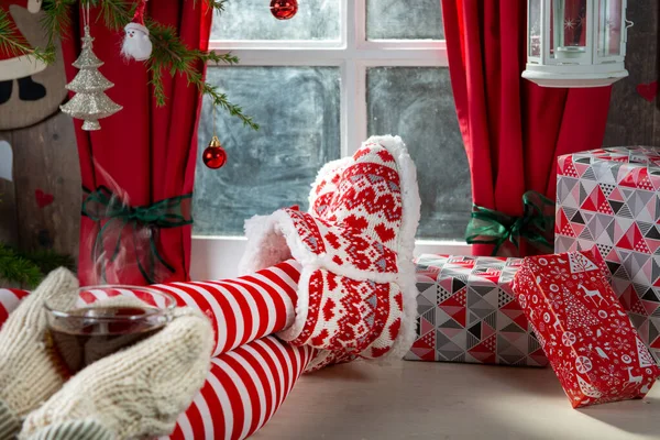 Szexi nő lábak zokni az asztalon és csésze tea, karácsonyi co — Stock Fotó