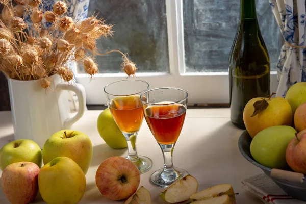 Garrafa e copos de cidra com maçãs. Em casa rústica, janela — Fotografia de Stock