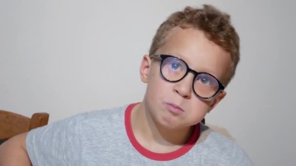 眼鏡をかけた少年がオレンジを食べて — ストック動画