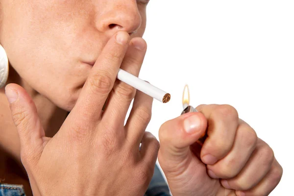 Jovem mulher acendendo cigarro no fundo branco — Fotografia de Stock