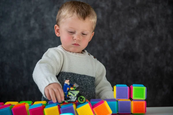 Portret van schattig jongetje spelen met motorfiets speelgoed — Stockfoto