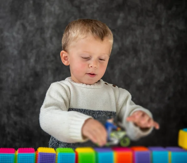 Portret van schattig jongetje spelen met motorfiets speelgoed — Stockfoto