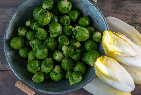 Spruitjes en andijvie op houten ondergrond, Belgische groenten — Stockfoto