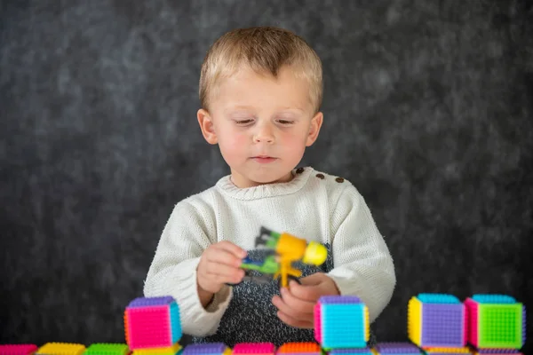 Portret van schattig jongetje spelen met motorfiets speelgoed — Stockfoto