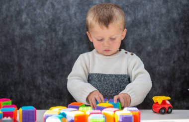 2 yaşında bir bebek küplerle oynuyor.