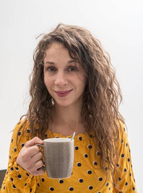 Uzun saçlı, güzel bir kızın elinde fincanla hayat tarzı portresi. 