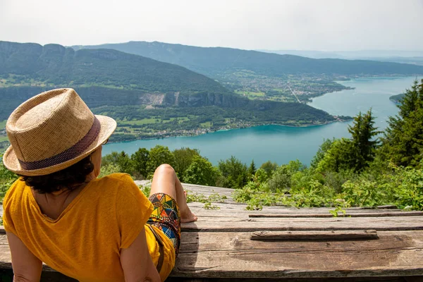 Woman looks at Lake Annecy in summer — Stok fotoğraf