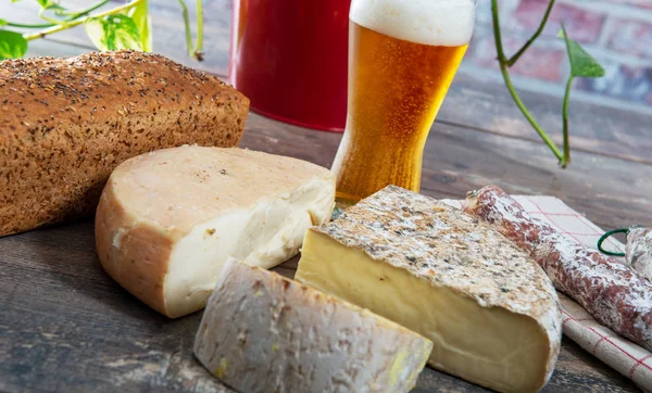 Quesos y Tomme de Savoie con cerveza, queso francés Savoy, jalá — Foto de Stock