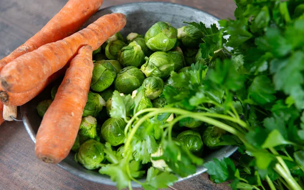 Carrots and Brussels sprouts on wooden background — Stock Photo, Image