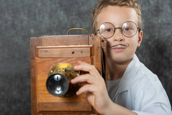 Cheerful boy retro photographer with vintage wooden camera — Stok fotoğraf