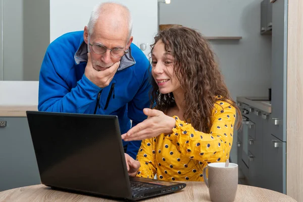 Fiatal nő segít idősebb laptop számítógép — Stock Fotó