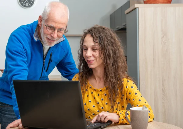 Fiatal nő segít idősebb laptop számítógép — Stock Fotó