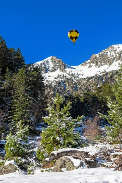 Zasněžené Pyrenejské hory se žlutým horkovzdušným balónem — Stock fotografie