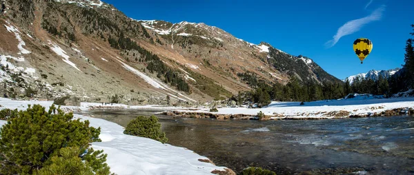 Río en las montañas nevadas de los Pirineos con globo de aire caliente amarillo —  Fotos de Stock