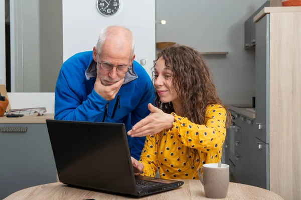 Young woman helps senior on laptop computer — Stock Photo, Image