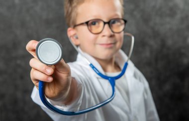Happy boy in doctor costume holding sthetoscope