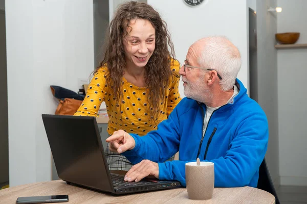 Fiatal nő segít idősebb laptop számítógép — Stock Fotó