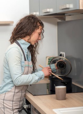 young woman with long hair is in the kitchen