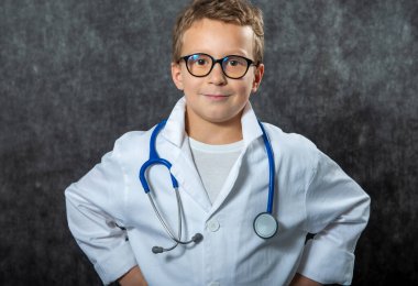 Yakışıklı çocuk tıp üniforması giyiyor doktorculuk oynuyor, portre çiziyor.