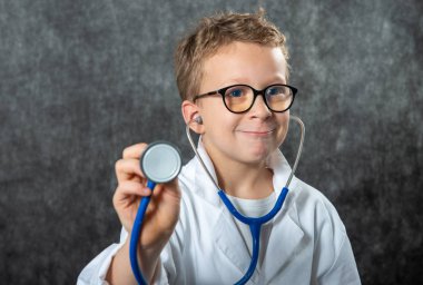 Yakışıklı çocuk tıp üniforması giyiyor doktorculuk oynuyor, portre çiziyor.