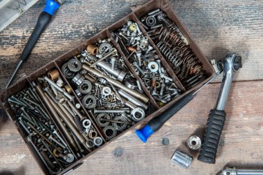 Küçük vidaları olan plastik bir alet kutusu. 