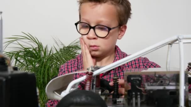 Маленький Мальчик Ремонтирует Модель Радиоуправляемой Машины Дома — стоковое видео