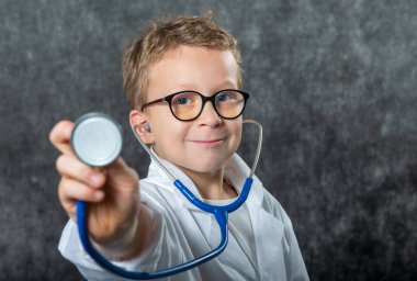 Yakışıklı çocuk tıp üniforması giyiyor doktorculuk oynuyor, portre çiziyor.