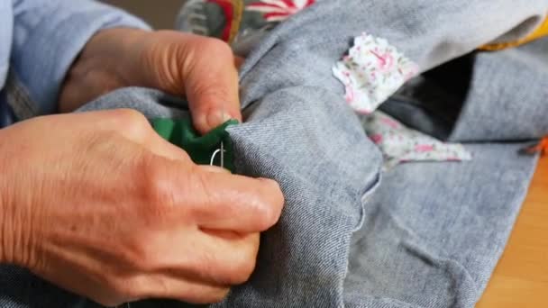 年配の女性の手は布に針を縫いつける 古いです女性手でパンツを縫う — ストック動画