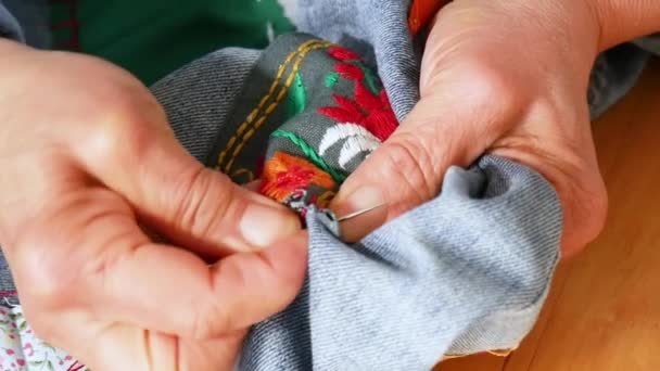 年配の女性の手は布に針を縫いつける 古いです女性手でパンツを縫う — ストック動画