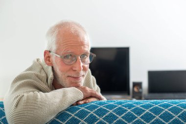 Gri saçlı, gözlüklü son sınıf öğrencisi.