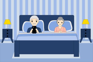 Yatakta yaşlı bir çift, telefonu izleyen bir adam ve bir kadın kızgın.