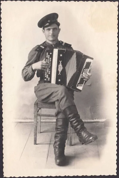 Scanned photo Russian soldier plays the accordion — Stock Photo, Image