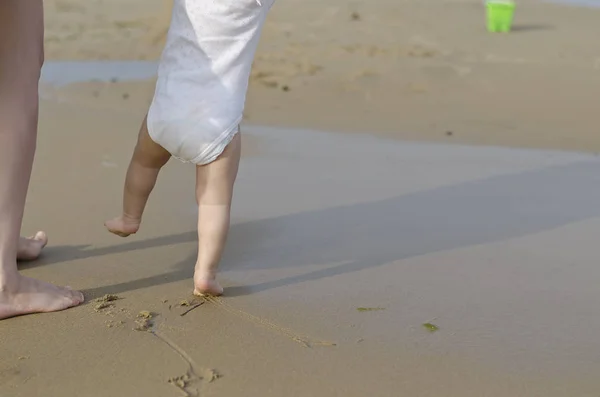 Schönes Baby, das auf dem Sand geht — Stockfoto